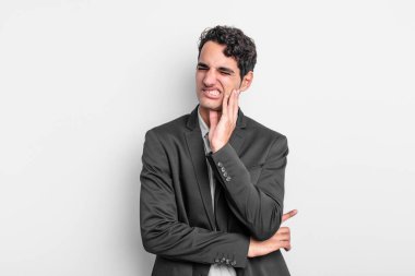 Yanak tutan ve acı çeken genç iş adamı, hasta, sefil ve mutsuz hisseden, dişçi arayan