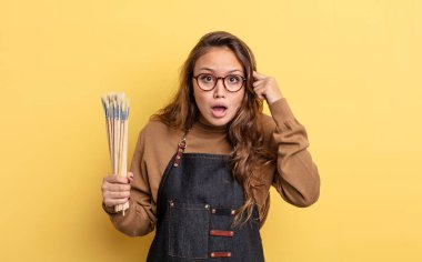 İspanyol güzel kadın şaşırmış görünüyor, yeni bir düşünce, fikir ya da konsept fark ediyor. Fırça konsepti olan sanatçı