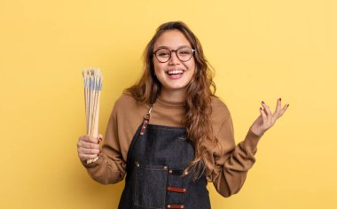 İspanyol güzel kadın kendini mutlu hissediyor, bir çözüm ya da fikir bulduğuna şaşırıyor. Fırça konsepti olan sanatçı