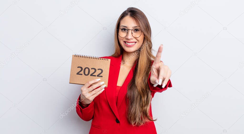 asiatic pretty woman smiling proudly and confidently making number one. calendar concept