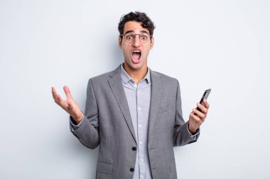 İspanyol yakışıklı adam son derece şaşırmış ve şok olmuş hissediyor. iş ve telefon kavramı