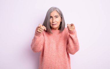 Üst düzey, güzel bir kadın kameraya iki parmağıyla ve kızgın bir ifadeyle bakarak sana görevini yapmanı söylüyor.