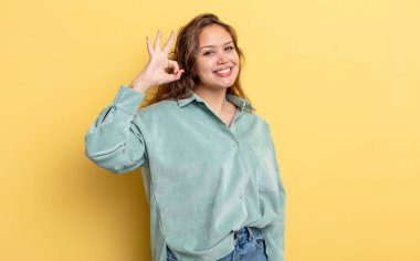 İspanyol güzel kadın kendini mutlu, rahat ve tatmin olmuş hissediyor. Onayını iyi bir hareketle gösteriyor. Gülümsüyor.