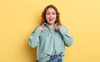 İspanyol güzel kadın mutlu, şaşkın ve gururlu hissediyor, heyecanlı, şaşkın bakışlarla kendini işaret ediyor.