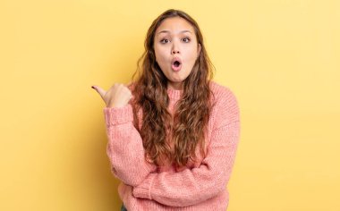 İspanyol asıllı güzel kadın inançsızlıktan şaşkın şaşkın bakıyor, yan taraftaki objeyi işaret ediyor ve diyor ki: