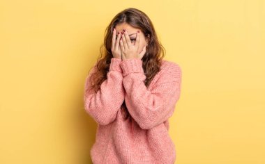 İspanyol güzel kadın korkmuş ya da utanmış hissediyor, gözleri yarı kapalı ya da elleri kapalı dikizliyor ya da dikizliyor.