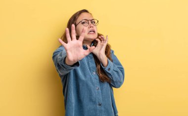 İspanyol güzel kadın korkmuş hissediyor, geri çekiliyor ve korku ve panik içinde bağırıyor, kabusa tepki veriyor.