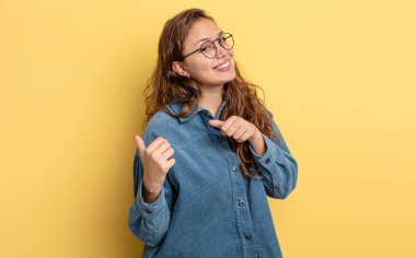 İspanyol güzel kadın neşeyle gülümsüyor ve yan taraftaki fotokopi alanını gösteriyor, mutlu ve tatmin olmuş hissediyor.