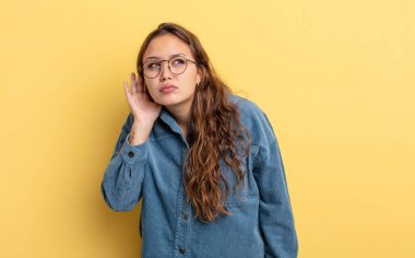 İspanyol güzel kadın ciddi ve meraklı görünüyor, dinliyor, gizli bir konuşma veya dedikodu duymaya çalışıyor, kulak misafiri oluyor.