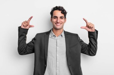 Genç işadamının gülümsemesini iki eliyle çerçevelemesi ya da özetlemesi, olumlu ve mutlu görünmesi, sağIık kavramı