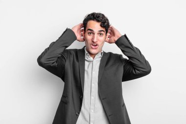 Genç işadamı heyecanlı ve şaşırmış görünüyor, ağzı açık, elleri başının üstünde, şanslı bir kazanan gibi hissediyor.