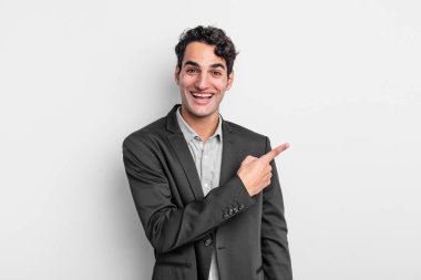 Genç işadamı heyecanlı ve şaşırmış görünüyor. Kenarlara ve yukarıya bakıp boşluğu kopyalıyor.