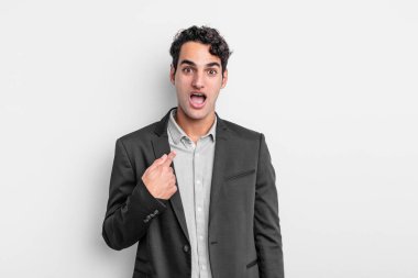 Genç işadamı ağzı açık, şaşkın ve şaşırmış görünüyor, kendini işaret ediyor.