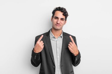 Kötü tavırlı genç işadamı gururlu ve agresif görünüyor, yukarıyı işaret ediyor ya da elleriyle alay işareti yapıyor.