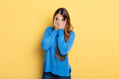 Asyalı güzel kadın korkmuş ya da utanmış hissediyor. Gözleri yarı kapalı ya da elleri kapalı dikizliyor ya da dikizliyor.