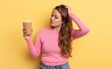 İspanyol güzel kadın mutlu bir şekilde gülümsüyor ve hayal kuruyor ya da şüphe ediyor. kahve konseptini kaldır.