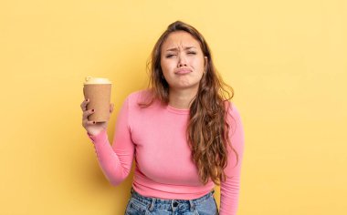 İspanyol güzel bir kadın üzgün ve mızmızlanıyor. Mutsuz bir bakışı var ve ağlıyor. kahve konseptini kaldır.