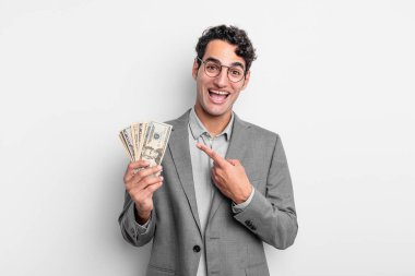 İspanyol yakışıklı adam heyecanlı ve şaşırmış görünüyor. iş ve dolar banknotları kavramı