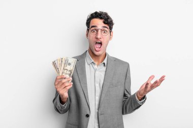 İspanyol yakışıklı adam inanılmaz bir sürprizle şaşkına dönmüş ve hayrete düşmüştü. iş ve dolar banknotları kavramı