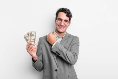 İspanyol yakışıklı adam kendini mutlu hissediyor ve bir meydan okumayla yüzleşiyor ya da kutluyor. iş ve dolar banknotları kavramı
