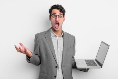 İspanyol yakışıklı adam inanılmaz bir sürprizle şaşkına dönmüş ve hayrete düşmüştü. iş ve dizüstü bilgisayar kavramı