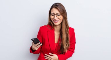Asyalı güzel bir kadın komik bir şakaya yüksek sesle gülüyor. iş ve telefon kavramı.