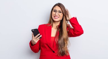 Asyalı güzel kadın stresli, endişeli ya da korkmuş hissediyor, elleri başının üstünde. iş ve telefon kavramı.