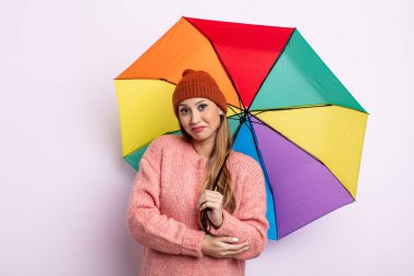 Asyalı güzel kadın omuz silkiyor, kafası karışık ve kararsız. şemsiye kavramı