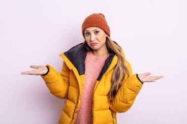 Asyalı güzel kadın şaşkın, şaşkın ve şüpheci hissediyor. kış konsepti