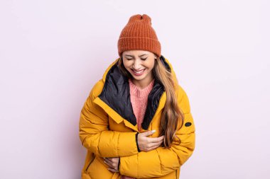 Asyalı güzel bir kadın komik bir şakaya yüksek sesle gülüyor. kış konsepti