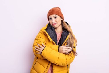 Asyalı güzel kadın omuz silkiyor, kafası karışık ve kararsız. kış konsepti