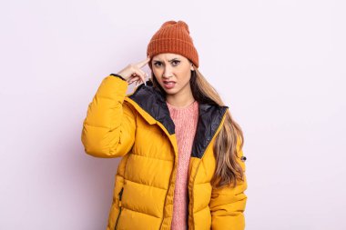 Asyalı güzel kadın kafası karışık ve şaşkın hissediyor, deli olduğunu gösteriyor. kış konsepti