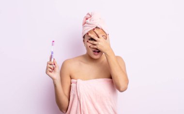 İspanyol güzel kadın şok olmuş, korkmuş ya da korkmuş görünüyor, yüzünü diş fırçası konseptiyle kapatıyor.