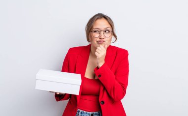 Hispanik güzel kadın düşünüyor, kuşkulu ve şaşkın hissediyor. paket ürün kavramı