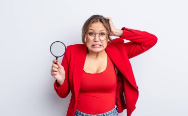 İspanyol güzel kadın kendini stresli, endişeli ya da korkmuş hissediyor, elleri başının üstünde. Büyütme cam konsepti