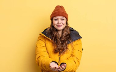 İspanyol güzel kadın gülerek dostça bir teklifte bulunuyor ve bir konsept gösteriyor. Kış giysileri