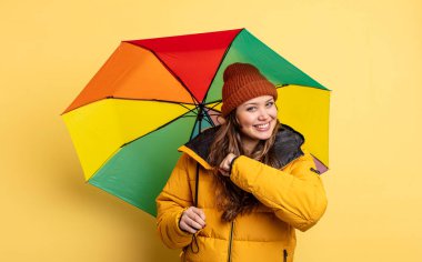 İspanyol güzel kadın kendini mutlu hissediyor ve bir meydan okumayla yüzleşiyor ya da kutluyor. şemsiye kavramı