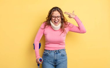 İspanyol güzel kadın mutsuz ve stresli görünüyor, intihar jesti silah işareti yapıyor. Koltuk değneği ve yaka kazası.