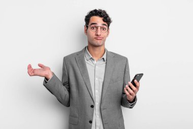 İspanyol yakışıklı adam şaşkın, şaşkın ve şüpheci hissediyor. iş ve telefon kavramı