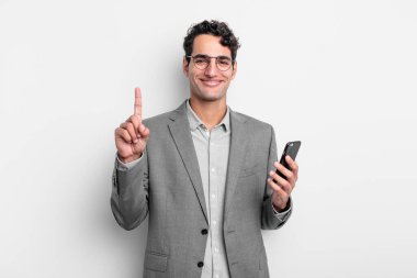 İspanyol yakışıklı adam gülümsüyor ve arkadaş canlısı görünüyor, bir numarayı gösteriyor. iş ve telefon kavramı