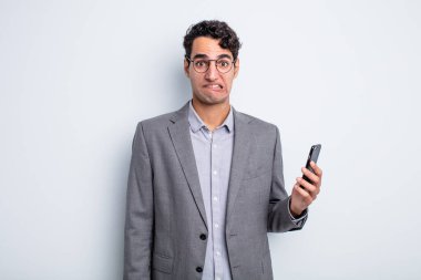 İspanyol yakışıklı adam kafası karışmış ve şaşkın görünüyor. iş ve telefon kavramı