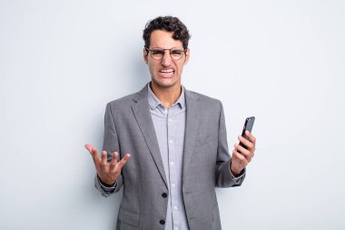 İspanyol yakışıklı adam sinirli, sinirli ve sinirli görünüyor. iş ve telefon kavramı
