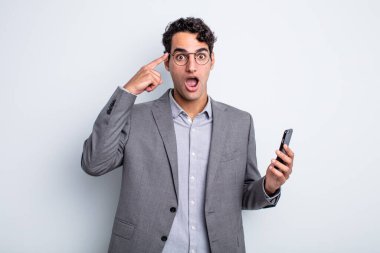 İspanyol yakışıklı adam şaşırmış görünüyor, yeni bir düşünce, fikir ya da konsept fark ediyor. iş ve telefon kavramı