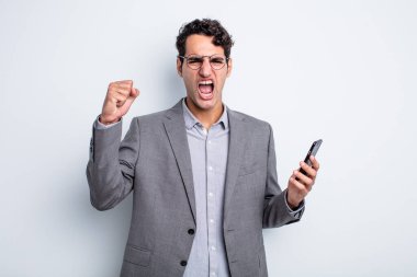 İspanyol yakışıklı adam sinirli bir ifadeyle agresif bir şekilde bağırıyor. iş ve telefon kavramı