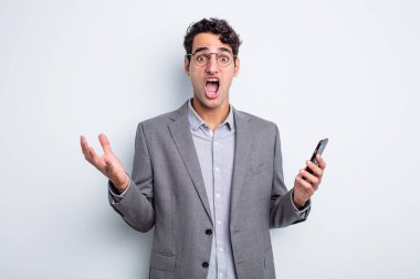 İspanyol yakışıklı adam son derece şaşırmış ve şok olmuş hissediyor. iş ve telefon kavramı