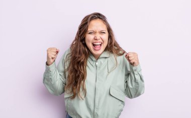 İspanyol asıllı güzel bir kadın öfkeli bir ifadeyle saldırganca bağırıyor ya da yumruklarıyla başarıyı kutluyor.