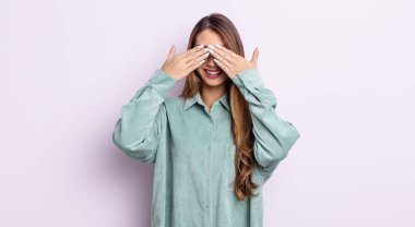 Asyalı güzel bir kadın gülümsüyor ve mutlu hissediyor, iki eliyle gözlerini kapatıyor ve inanılmaz bir sürpriz bekliyor.