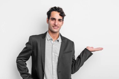 Genç işadamı gülümsüyor, kendinden emin, başarılı ve mutlu hissediyor, fotokopi alanında fikir veya konsept gösteriyor.