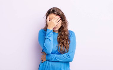 İspanyol güzel kadın stresli, utanmış ya da üzgün görünüyor, baş ağrısı var, yüzünü eliyle kapatıyor.