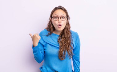 İspanyol asıllı güzel kadın inançsızlıktan şaşkın şaşkın bakıyor, yan taraftaki objeyi işaret ediyor ve diyor ki: